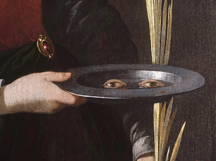 Detail of a vintage painting showing a pair of eyes presented on a silver plate